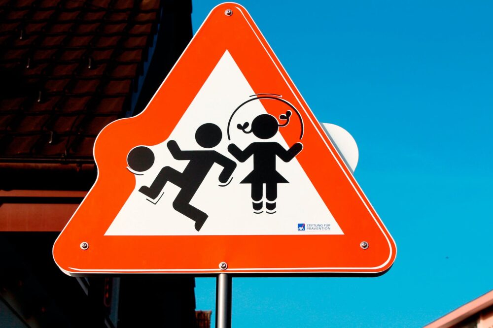 red and white children playing road signage