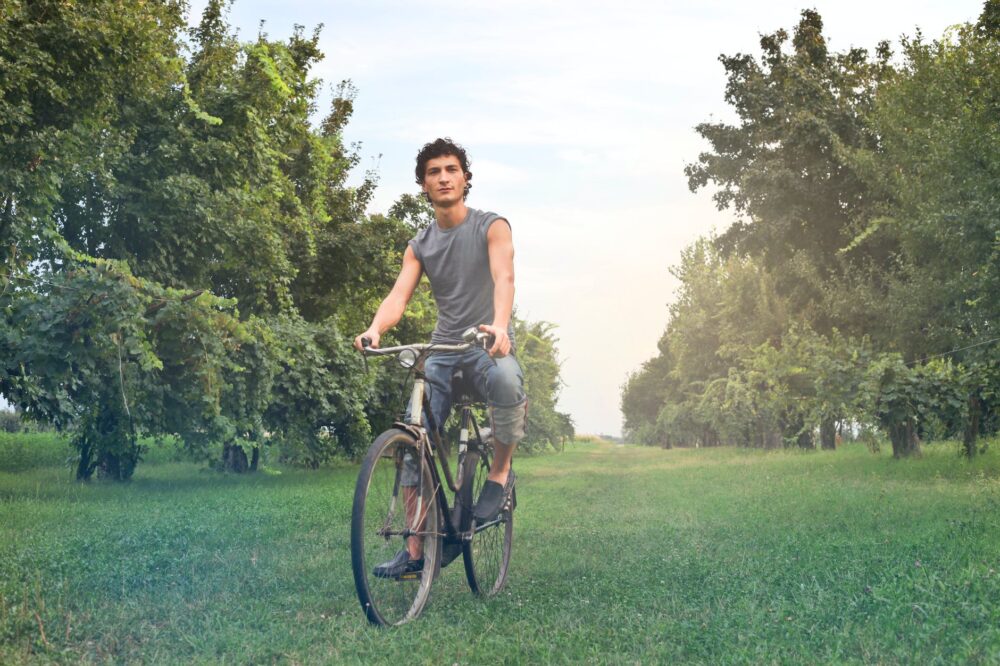 man in gray sleeveless shirt riding bike